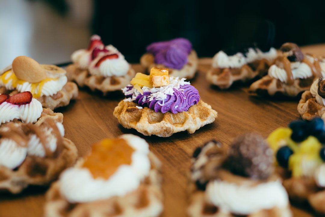 assorted decorative dessert waffles topped with colorful icing and fruit